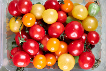 food containers with colorful cherry tomatoes stands on the table top view