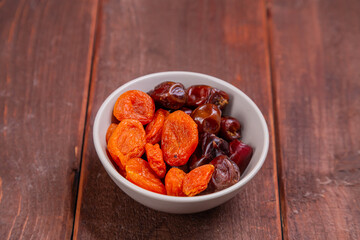 Dried dates and apricots in a bowl on a wooden table iftar suhoor ramadan month
