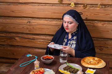 A Muslim woman in a blue hijab and embroidered national dress at a set