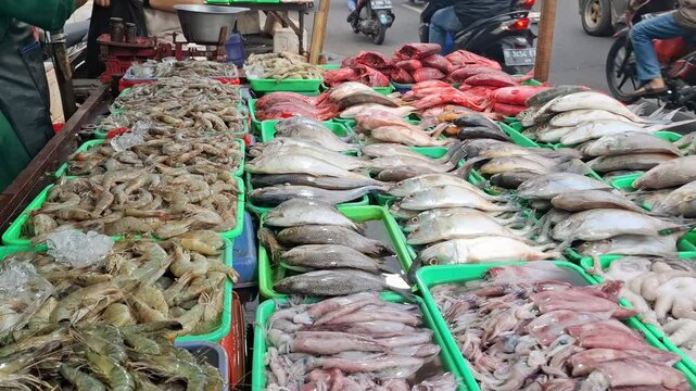 Traders sell mackerel, catfish, red snapper, shrimp, squid and several other freshwater fish to buyers who are bargaining for fish to buy at the traditional market.