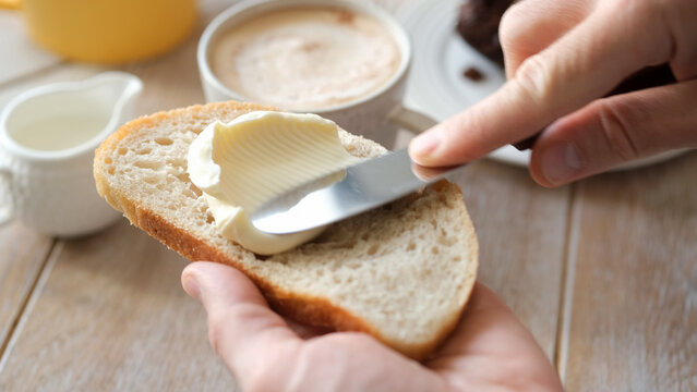 Spreading soft butter on white bread toast, closeup view - Powered by Adobe