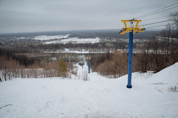 A ski lift ascends a snowy hill, showcasing the charm and excitement of winter, making it perfect...