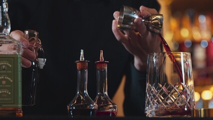 Closeup hand bartender holding jigger to measure liquor sugar into mixing glass ingredients alcohol preparation creative mixed cocktail. Special refresh drink showcasing nightlife mixology. Vinosity.