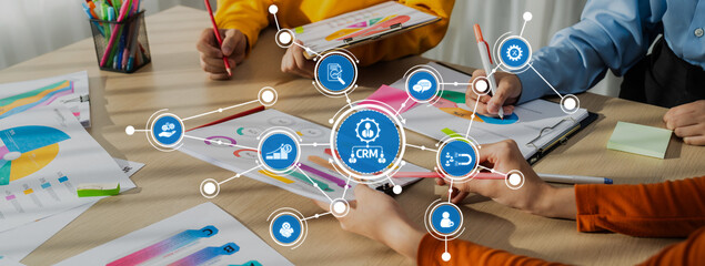 A vibrant team collaboration scene featuring diverse individuals engaged in a strategy session, utilizing graphs and flowcharts on a workspace to foster innovative ideas and planning. Amity