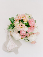 Bridal bouquet with pink and white flowers arranged elegantly for wedding day celebration in soft lighting