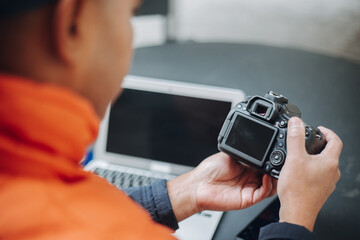 Photographer reviewing photos on camera and laptop during a break, ensuring quality and making adjustments