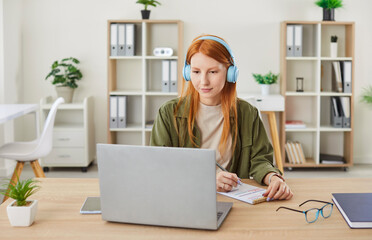 Woman student studies at home, actively participating in an online video call for a remote lecture....