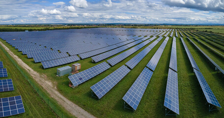 Aerial view of big sustainable electric power plant with many rows of solar photovoltaic panels for...