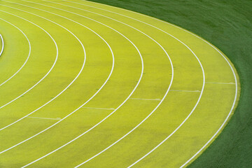 Curving lanes of an outdoor athletics stadium on a sunny day