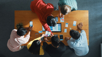 Top view of software developer team looking Ux Ui design for mobile phone interface from tablet...
