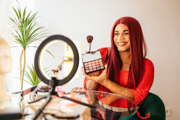 Transgender influencer showing makeup palette while recording video