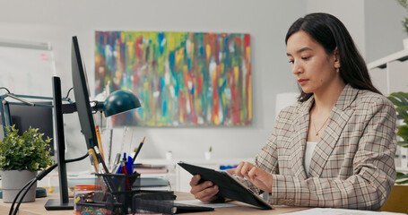 A conscientious organized office worker in a large corporation sits at desk synchronizing documents...