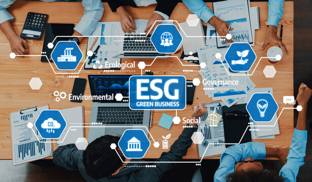 A diverse team collaborates over data and reports, focusing on ESG strategies for sustainable business. The image highlights modern corporate practices in a dynamic workspace. Amity