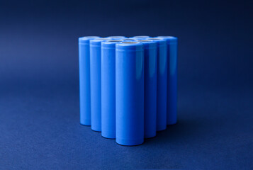 Many AA cell batteries on blue background, closeup