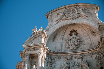View of the top of the beautiful baroque facade of the Santa María cathedral in Murcia, Spain with...