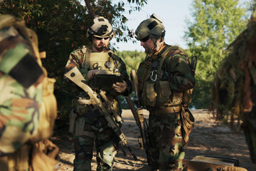 The military prepares for a field exercise as soldiers in camouflage uniforms with rifles and...