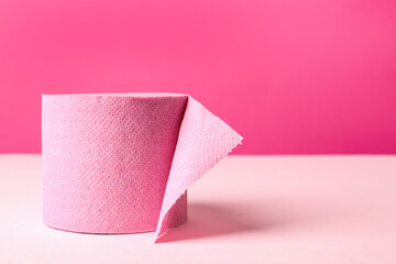Color toilet paper roll on pink background. Space for text