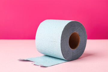Blue toilet paper roll on pink background