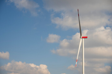 A wind turbine with a blue sky and clouds.  Concept of clean energy.