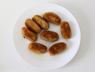 Plate of homemade croquettes on a white background.