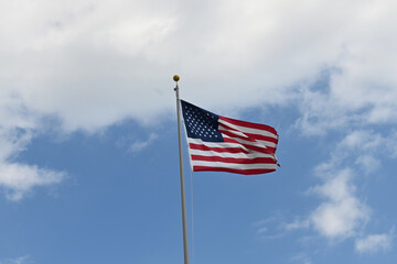Close up full frame of United States of America flag flying in the wind with blue sky background
