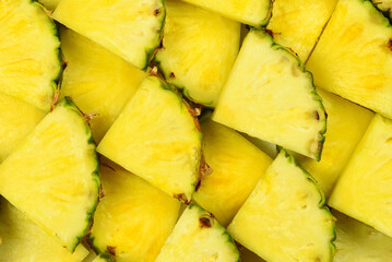 Pineapple juicy yellow slices background. Top view.