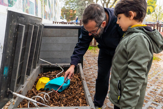 Father and son learning about composting in urban garden