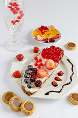Delicious Breakfast with Toast Berries and Chocolate Cookies on a Light Background