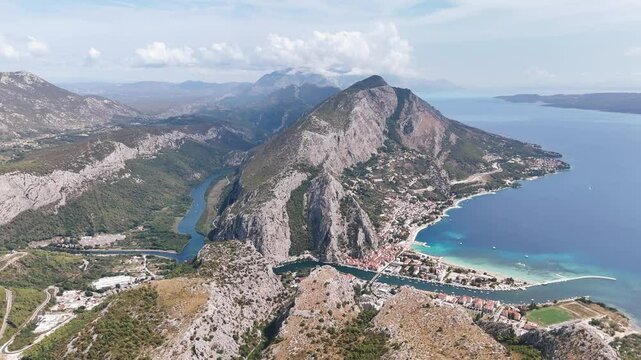 Aerial panorama of the shoreline of Omis, Cetina river canyon and Dinaric Alps. Balkan Peninsula, Croatia