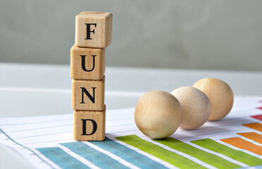 FUND - acronym on wooden cubes on a graph background