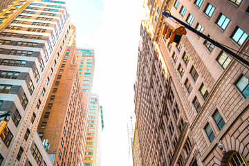 Tall giant buildings in the city streets of New York City Manhattan USA low angle view skyscrapers urban architecture high-rise buildings downtown skyline commercial real estate