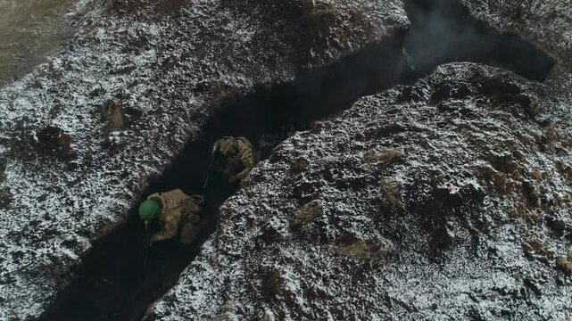 Ukrainian soldiers in trenches and smoke from explosions
