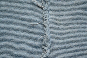 torn light grey denim surface, denim fringe , hole macro texture of blue denim, torn blue denim...