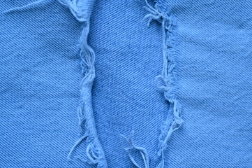 torn light grey denim surface, denim fringe , hole macro texture of blue denim, torn blue denim...