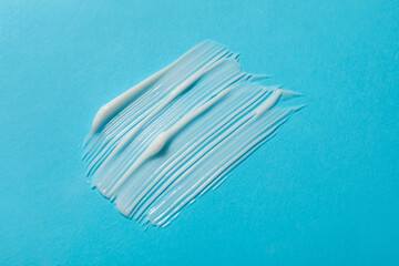 Body cream on light blue background, top view