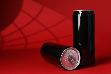 Two tin cans on red background with shadow. Space for text