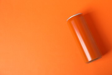 One tin can on orange background, top view. Space for text
