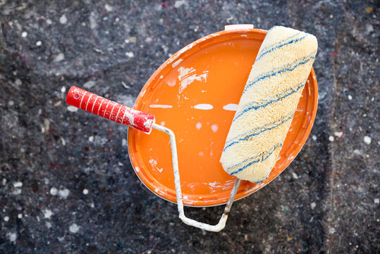 Paint bucket with roller on painter's fleece. Tools for home renovations.