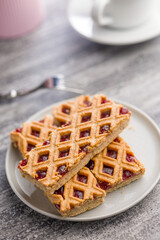 Sweet linzer cake on plate on kitchen table.