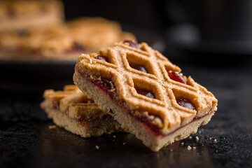 Sweet linzer cake on black table.