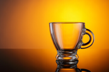 Empty Espresso Glass Cup with Warm Orange Background