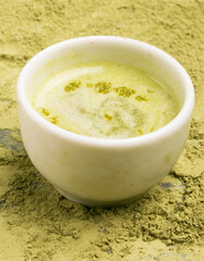 cup of matcha tea with tea powder background
