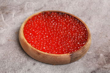 wooden plate with red caviar
