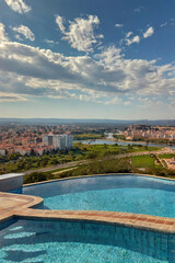 Obraz premium Infinity Pool Overlooking a Scenic Town and Landscape