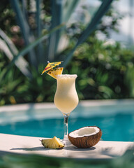 Pina Colada cocktail on the beach with coconut and exotic flower