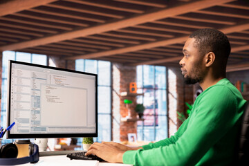 Man in home office looking at UI on PC screen, typing and executing programming code. Coding...
