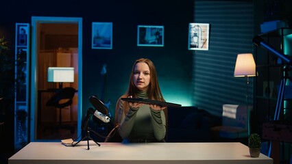 Young entertainer presenting sleek laptop from brand sponsoring video, urging viewers to purchase...