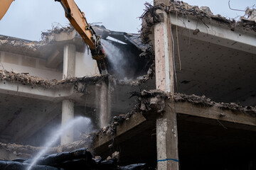 Demolition of a concrete building with machinery in action