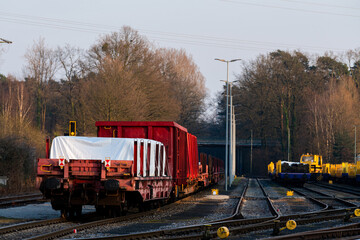 Red train cars parked at railway yard during afternoon