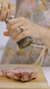 Poni&eacute;ndole pimienta con un pimentero a un trozo de carne. Sazonado, preparaci&oacute;n de carne. Footage de cocina, asado, carne 